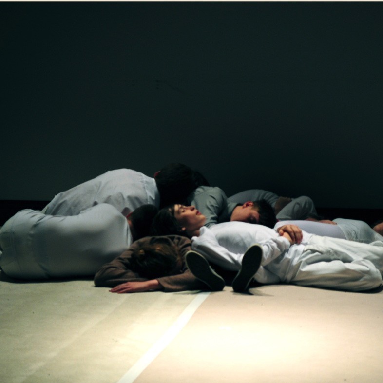Bodies lay on the floor of a white space