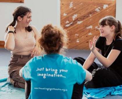 Youth Theatre members taking part in a session, talking with a facilitator.