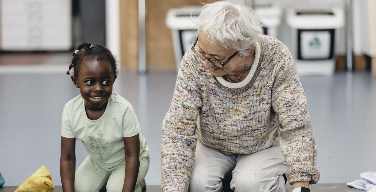 Travelling Light artist Edwina Bridgeman sits next to a child during our R&D session for a new early years show.