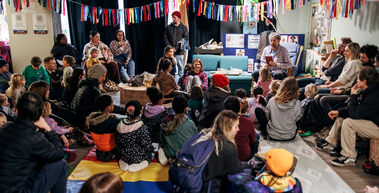 Children and their families sitting and taking part in a storytelling workshop during Winter Ligths. Photo by Edward J Feltno