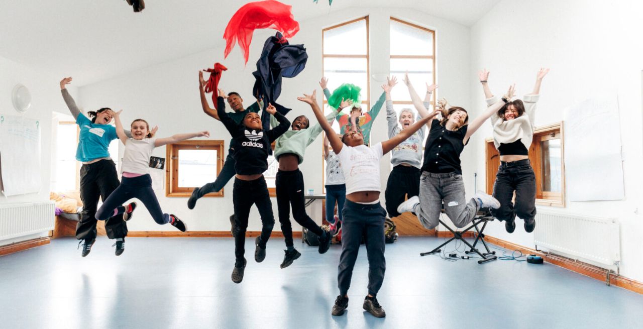 Travelling Light children and artists jumping for joy in the Travelling Light studio.