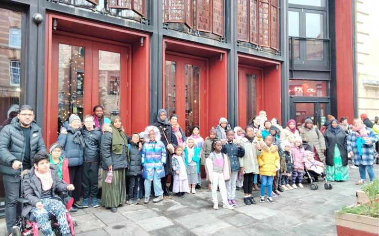 Families standing outside Bristol Old Vic before going in to enjoy Belle and Sebastien.