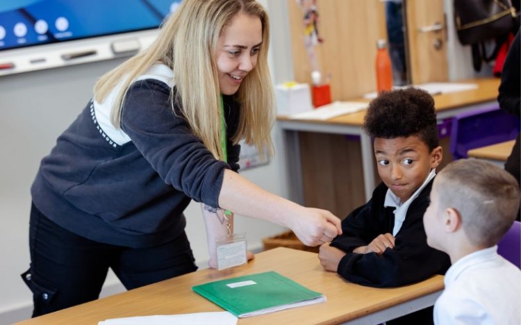 Two pupils taking part in a drama based activity with their teacher during our Light Up School Learning project.